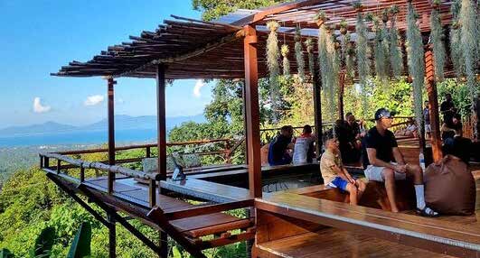 Wooden terrace of a café overlooking the jungle and the sea.